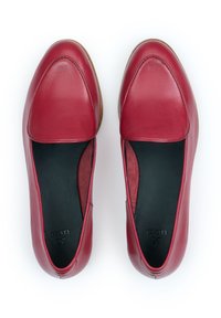 Czerwone skórzane mokasyny o gładkim wykończeniu, zaokrąglonym nosku i czarnym wnętrzu. Charakteryzują się niskim profilem i minimalną ilością przeszyć.