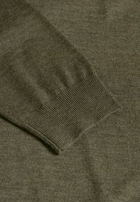 Olivgrön stickad tröja med ribbade ärmslut och en mjuk textur, utan sömmar och utan utsmyckningar eller mönster.