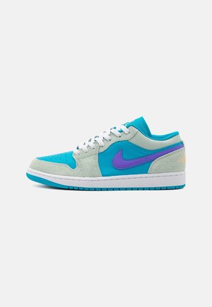 Baskets Nike avec une tige en suède et textile turquoise, des accents violets, et une semelle en caoutchouc blanche avec des détails texturés.