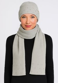 Set di berretto e sciarpa a coste grigio chiaro, con piccole perline decorative, tessuto morbido e vestibilità aderente.