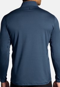 Langarm-Sportshirt in Dunkelblau mit hohem Kragen, glatter Textur und Flatlock-Nähten an den Ärmeln und dem Saum für Komfort und Langlebigkeit.