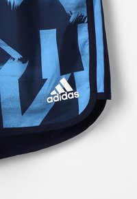 Pantalones cortos deportivos de Adidas en azul y marino, con patrones abstractos, una textura suave y un logo blanco en el dobladillo.
