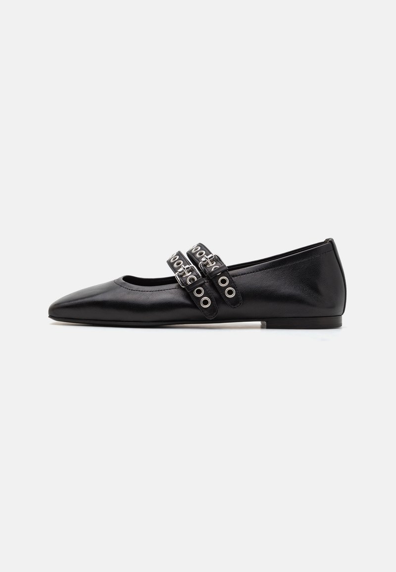 Zapatos planos de cuero negro con puntera afilada, que cuentan con dos correas decorativas con ojales de metal sobre el empeine. Textura suave y ligero brillo.
