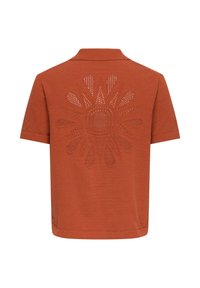 Polo manches courtes orange rouille avec un motif soleil perforé dans le dos et un col plat.