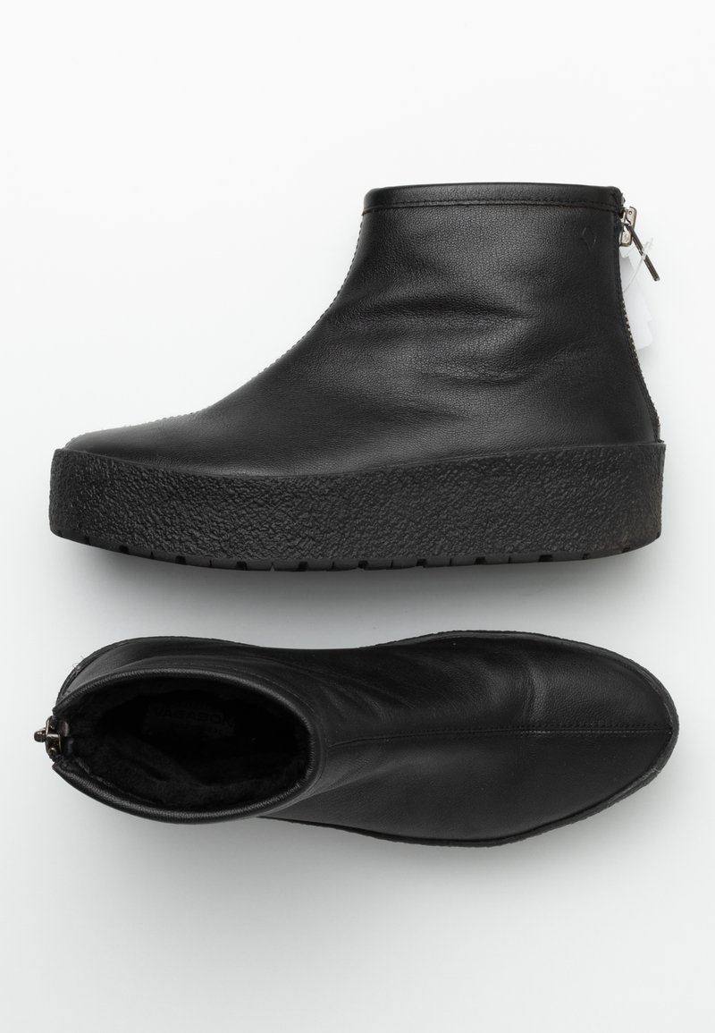 Bottes ankle en cuir noir avec semelles épaisses et texturées, fermeture éclair latérale et tige lisse. Une botte vue de côté, une vue de dessus.