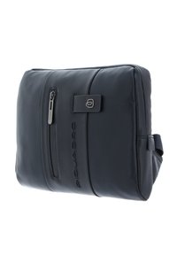 Borsa in pelle blu navy con texture liscia, dotata di una tasca frontale con zip, logo impresso e una tracolla laterale per un facile trasporto.