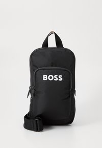Crna tkanina ruksak s gornjom drškom i podesivim trakama. Ima prednji džep sa patentnim zatvaračem i s 'BOSS' logotipom u bijeloj boji. Glatka tekstura.