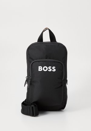 Black fabric backpack with a top handle and adjustable strap. Features a front zip pocket with 'BOSS' logo in white. Smooth texture.