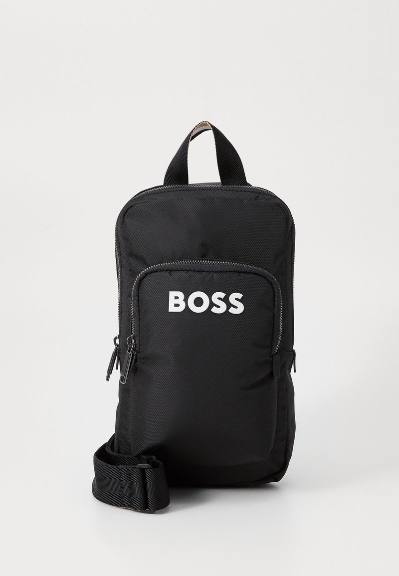 Crna tkanina ruksak s gornjom drškom i podesivim trakama. Ima prednji džep sa patentnim zatvaračem i s 'BOSS' logotipom u bijeloj boji. Glatka tekstura.