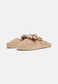 Lysebrune ruskind slip-on sko med knyttede detaljer, der har en sål af jute-reb og en glat overflade på den øverste del.
