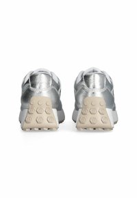 Sneakers sportivi argento con una superiore metallica testurizzata, accenti bianchi e una suola in gomma beige con motivi di trazione esagonali.