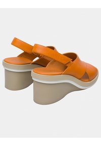 Oranje leren plateau schoenen met een brede band en een ronde neus. Kenmerkt zich door een chunky beige hak met een witte accentlijn.
