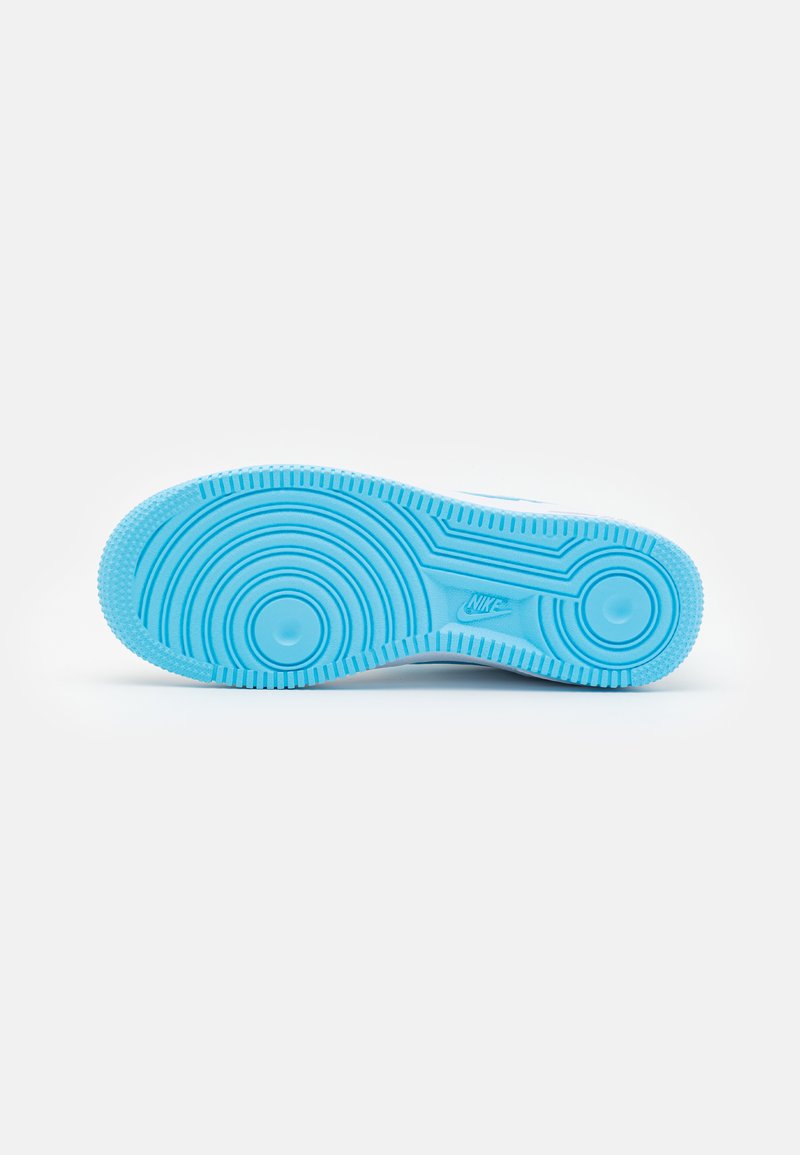 Suola blu di una sneaker Nike che mostra motivi a treccia circolari e il logo Nike al centro su uno sfondo bianco.