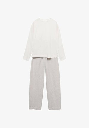 Bijela bluza dugih rukava s okruglim izrezom uparena s svijetlo sivim, teksturiranim hlačama širokih nogavica koje imaju uzorak poput vafla.