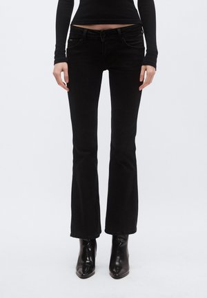 Crne traperice širokih nogavica s srednjim strukom, prednjim džepovima i petljama za remen. Tkanina ima glatku teksturu i blagi rastezljivost, što poboljšava pristajanje.