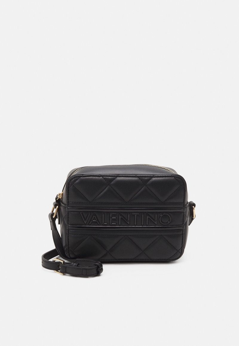 Černá prošívaná crossbody taška Valentino s embosovaným logem, zipem v zlatém tónu a nastavitelným popruhem na bílém pozadí.