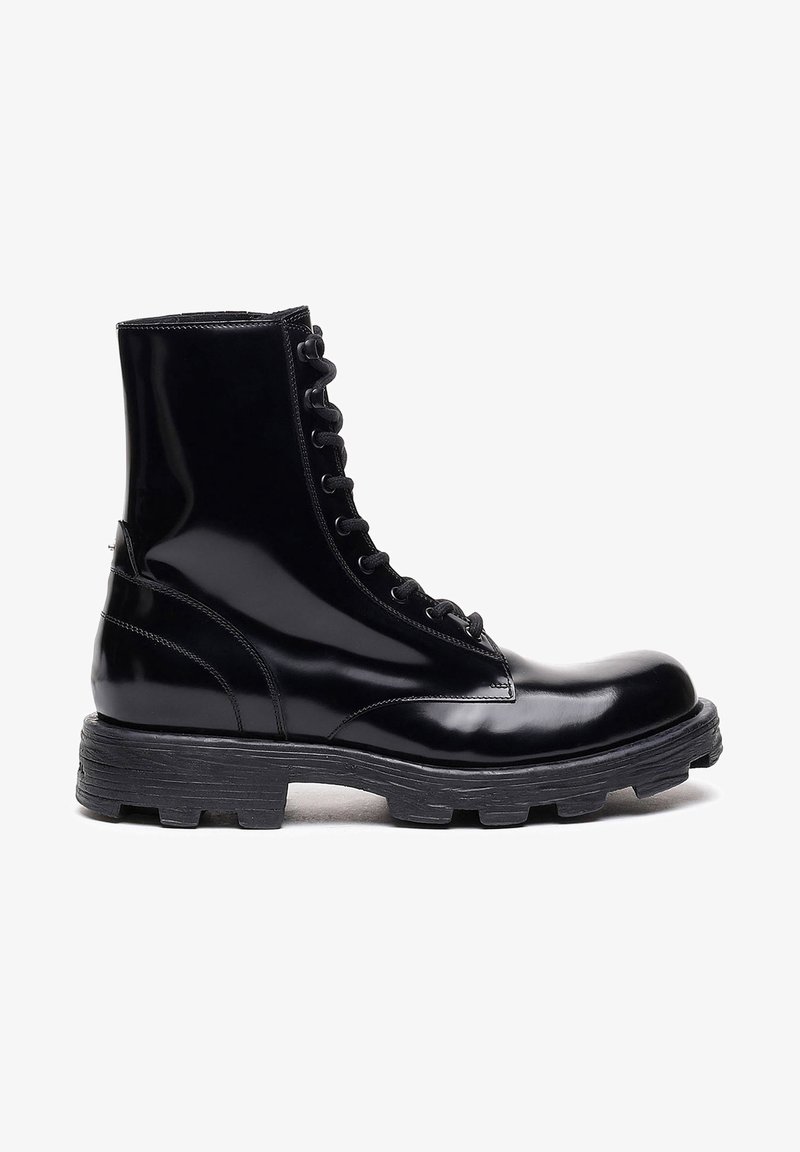 Stivaletti in pelle patinata nera con punta arrotondata, allacciatura frontale e suola in gomma texturizzata. Finitura liscia e silhouette strutturata.