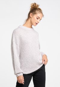 Pulover tricotat chunky, gri deschis, cu guler rotund, mâneci supradimensionate, manșete cu model și un tiv ușor curbat. Textură moale și croială relaxată.