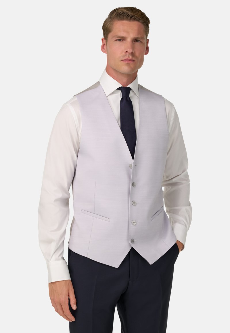 Jasnofioletowa kamizelka o teksturowym wykończeniu, z dekoltem w serek, pięcioma guzikami i dwiema przednimi kieszeniami. Zestawiona z białą koszulą i granatowym krawatem.