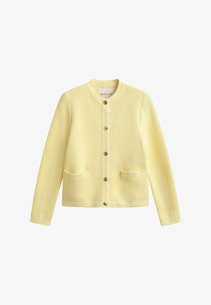 Cardigan boutonné jaune clair à manches longues, col rond, deux poches avant et boutons dorés.