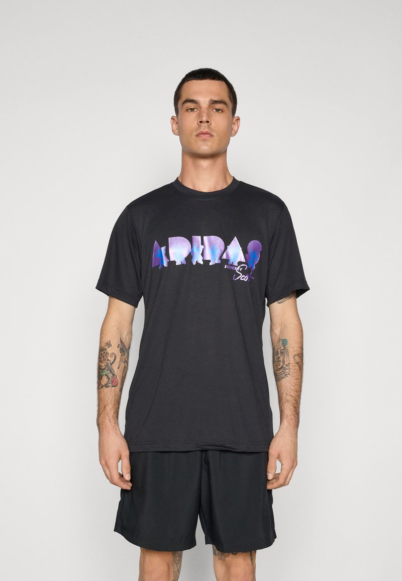 Sort kortærmet t-shirt med et flerfarvet "ADIDAS" logo på brystet. Stoffet ser blødt ud, med en afslappet pasform.