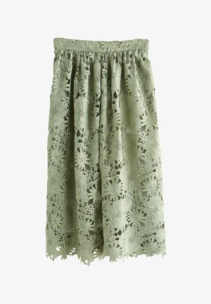 Grüner Midirock mit floraler Spitzenüberlagerung, geraffter Taille und wellenförmigem Saum, mit detaillierten Blumenmustern auf dem gesamten Stoff.