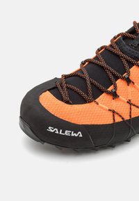 Adidaș negru și portocaliu, cu parte superioară din plasă, vârf din cauciuc și talpă texturată. Dispune de șireturi contrastante și logo-ul brandului pe lateral.