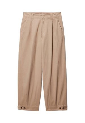 Pantalon beige à jambes larges avec taille haute, présentant des plis, des poches latérales et des boutons décoratifs aux poignets. Confectionné en tissu de coton.