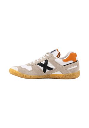 Sneaker beige e bianco a basso profilo con X nero laterale, patch arancione sul tallone, lacci bianchi e suola in gomma.