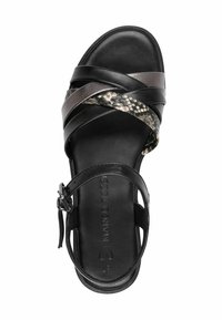 Sort lædersandal med krydsende stropper, der har et struktureret mønster og en lille ankelrem. Glat overflade med et stilrent design.