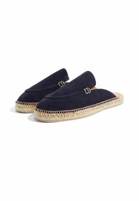 Zapatos de ante azul marino tipo slip-on con detalles de cuerda de yute alrededor de la suela y acentos de costura. Presenta una textura suave y un diseño de punta redonda.