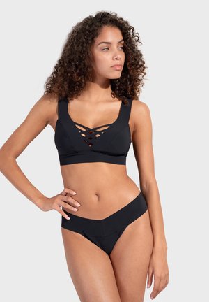 Czarny zestaw bikini z braletką o V-kształtnym przodzie i krzyżującymi się detalami, połączony z pasującymi, niskimi majtkami.