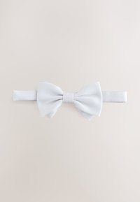 White fabric bow tie with a textured finish, featuring a central knot and attached adjustable strap for fastening.