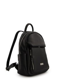 Schwarzer Leder-Rucksack mit strukturierter Oberfläche, oberem Griff, verstellbaren Trägern, vorderer Reißverschlusstasche und metallischem Logo-Schild.