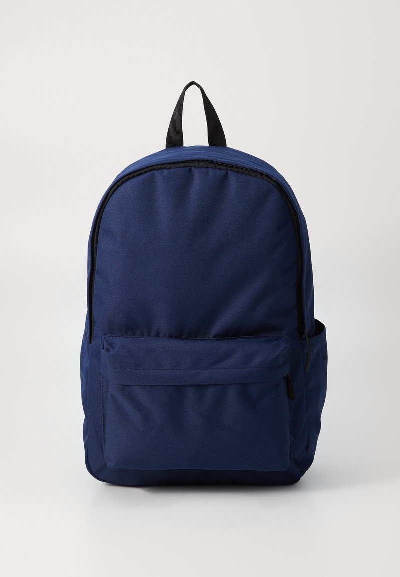 Sac à dos bleu marine avec une poche avant zippée, des poches latérales et une poignée supérieure noire sur un fond clair uni.