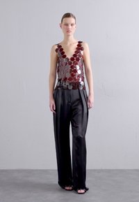Sequin-embellished sleeveless top with a deep V-neck in burgundy and silver, paired with high-waisted black satin trousers.