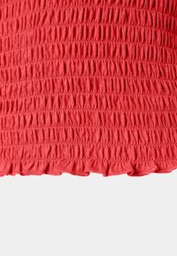 Tecido vermelho com uma textura franzida, apresentando pregas horizontais, terminado com uma bainha com babados. O material é macio e elástico.
