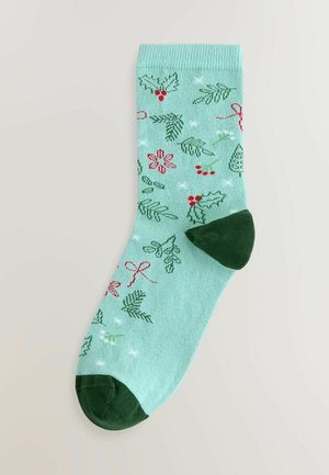 Sosete cu un model verde și mentă, decorate cu ilex, vâsc și panglici, având vârful și călcâiul de culoare verde închis, fabricate dintr-un material textil moale.