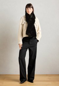 Beige cropped jacket with pockets, black faux fur scarf, black wide-leg trousers, and pointy black shoes; smooth textures and clean lines.