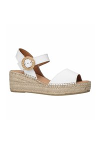 Witte leren sleehakken met een espadrille zool. Kenmerkt zich door een crisscross ontwerp, een verstelbare riem en een ronde gehaakte accent op de riem.