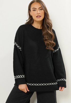 Maglione nero a maglia con una vestibilità ampia e maniche lunghe. Presenta accenti bianchi ricamati lungo le maniche e l'orlo. Tessuto strutturato.