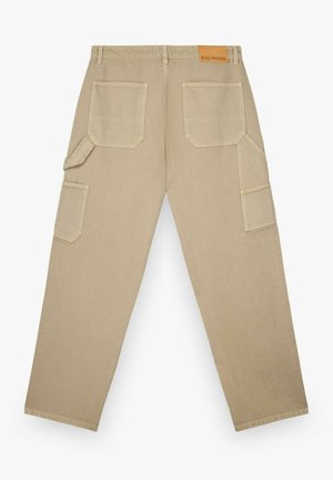 Beżowe spodnie robocze o prostych nogawkach, z dwoma tylnymi kieszeniami, dwoma bocznymi kieszeniami, szlufkami na pasek oraz małą beżową metką z napisem "BALMOHK" na pasie.