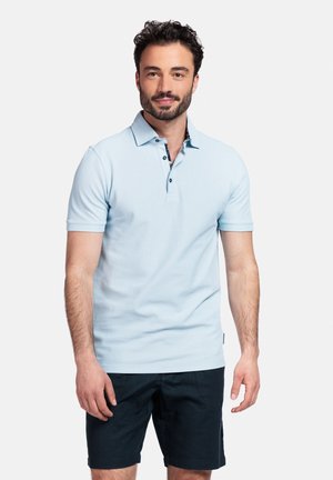 Chemise polo bleu clair avec un col, comportant trois boutons foncés, associée à un short bleu marine. Le tissu semble lisse et texturé.