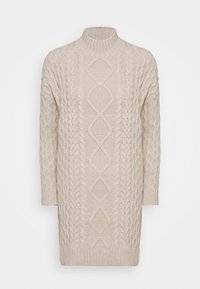 Vestido de punto beige con mangas largas y cuello acanalado alto, que presenta patrones de diamantes y trenzas en la parte delantera.