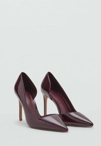 Lakierowane bordowe czółenka na wysokim obcasie, zamszowe, ze szpiczastym noskiem i eleganckim, wyciętym wzorem po bokach. Szpilki dodają wysokości.
