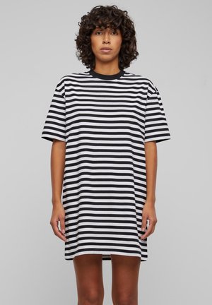 Sukienka t-shirt w pionowe czarno-białe paski, oversize, z krótkimi rękawami, okrągłym dekoltem, długości do połowy uda, wykonana z miękkiej bawełny, o luźnym kroju.