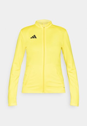 Yellow zip-up jacket made of smooth fabric, featuring a high collar, two side pockets, and a black Adidas logo on the upper left.