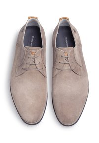 Scarpe in suede marrone con lacci, dalla texture liscia, punta rotonda e dettagli di cucitura delicati. Presentano un accento beige sul tallone.