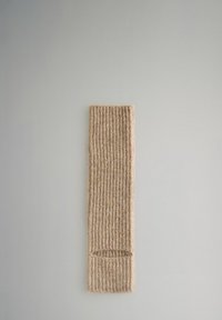 Béžová pletená nohavice s ribbovanou texturou a otvorem na jednom konci, vystavená plochá na světlém šedém pozadí.