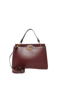 Borsa in pelle bordeaux con finitura liscia, hardware dorato, manico superiore e tracolla staccabile. Presenta un design curvo e un accento con logo.